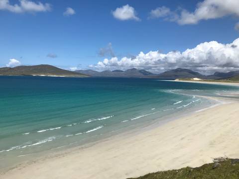 Wide view of a pristine beach with turquoise water.