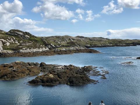 Rocky coastline with calm waters under a clear sky.