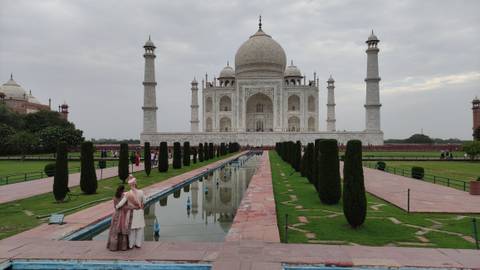       The iconic Taj Mahal with its reflecting pool and visitors.
  