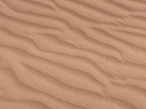 Close-up of textured sand with ripples.