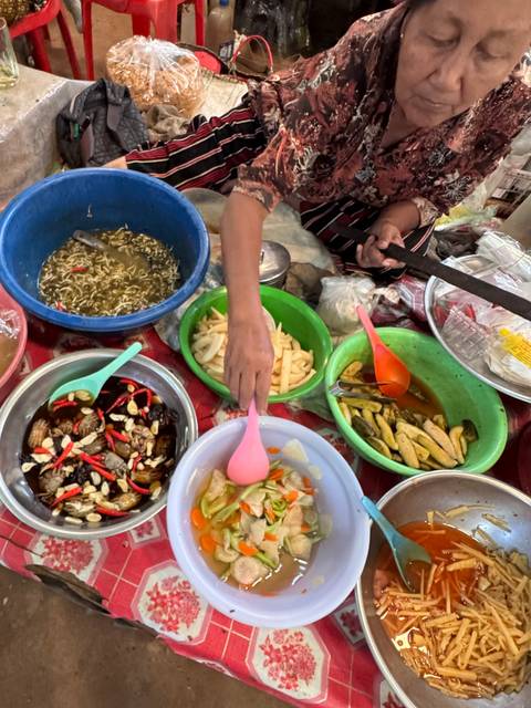 Hand reaching into bowls of various traditional foods.