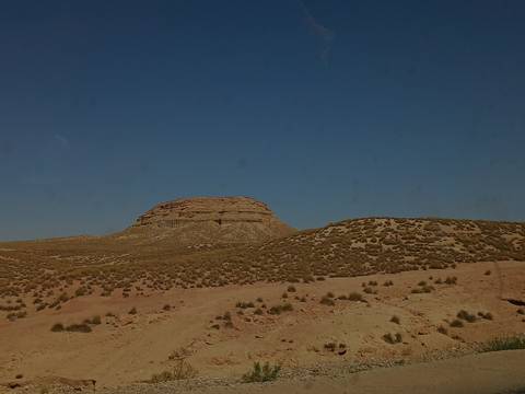       Desert landscape with a hill against a clear sky.
  