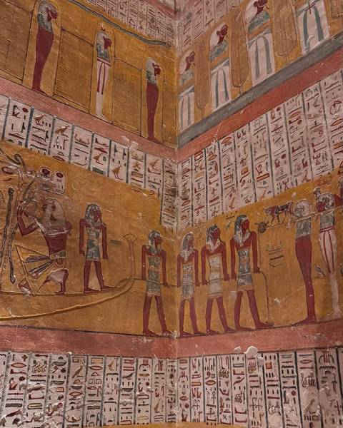 Ancient Egyptian hieroglyphs and murals on a temple wall.