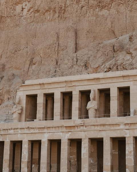 Ruins of ancient Egyptian temple with statues.