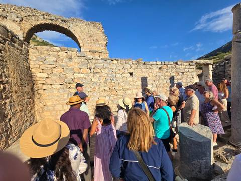 Group of people exploring ancient ruins with stone walls and archways.