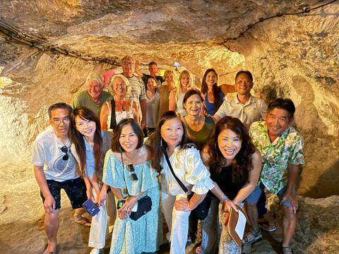 Group of people smiling inside a cave or tunnel.