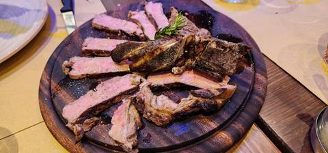       Slices of meat on a wooden board.
  