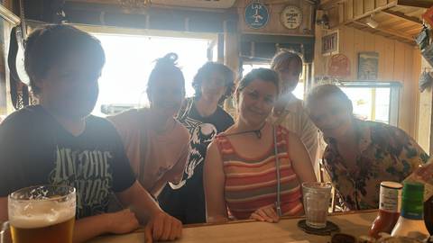       Group of people at a bar with drinks.
  