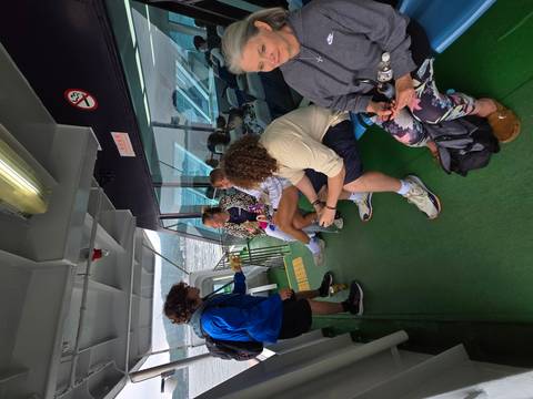       Group of people sitting on a ferry.
  