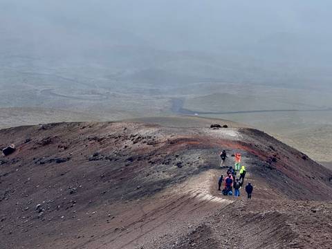       Small group of people hiking on a rocky terrain.
  