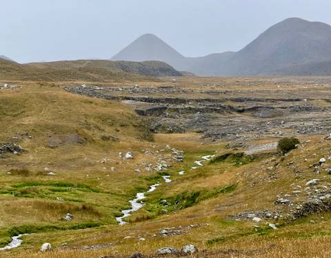      Rocky landscape with a stream flowing through.
  