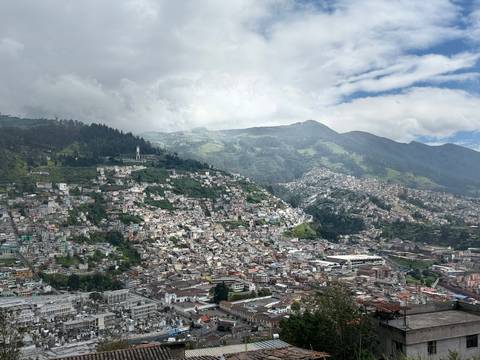       Aerial view of a large city with surrounding mountains.
  
