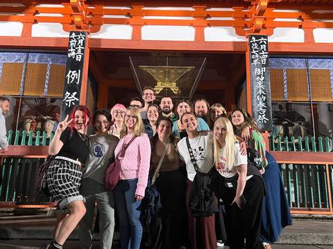       Group of people posing in front of a temple.
  