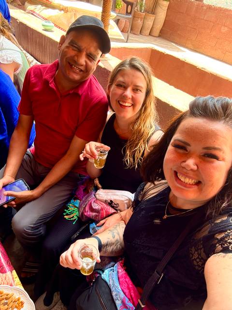 Group of people enjoying tea inside a warm setting.