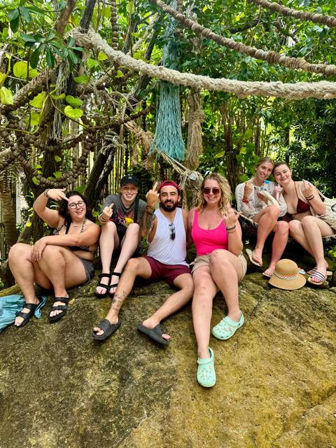 Group of people sitting in a natural setting.