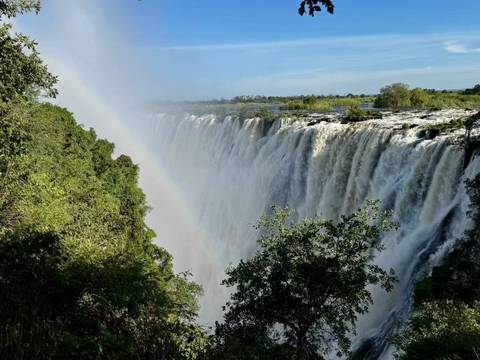 Victoria Falls with a rainbow across the mist.
