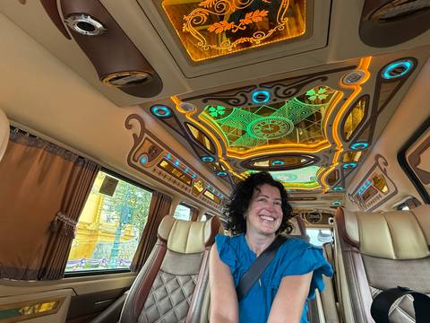       A woman sitting inside a beautifully decorated vehicle.
  