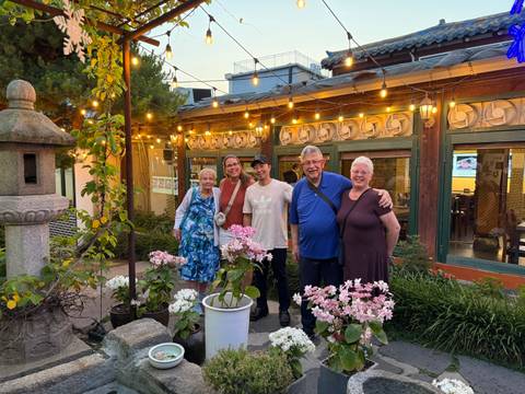 A group of people posing in a garden setting.
