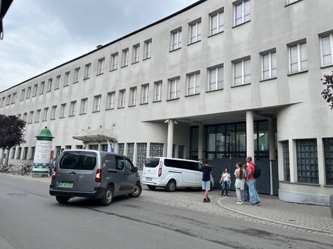       People standing in front of a modern building.
  