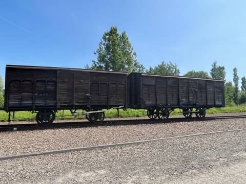       Wooden train cars on a railway track.
  