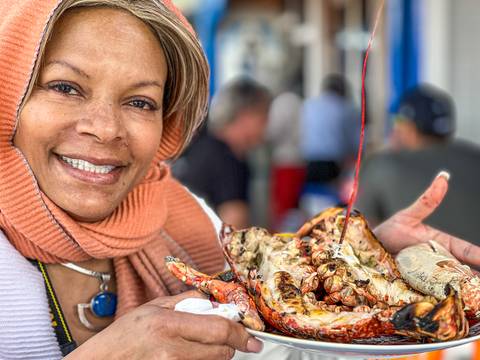 Person holding a plate of seafood with a smile.