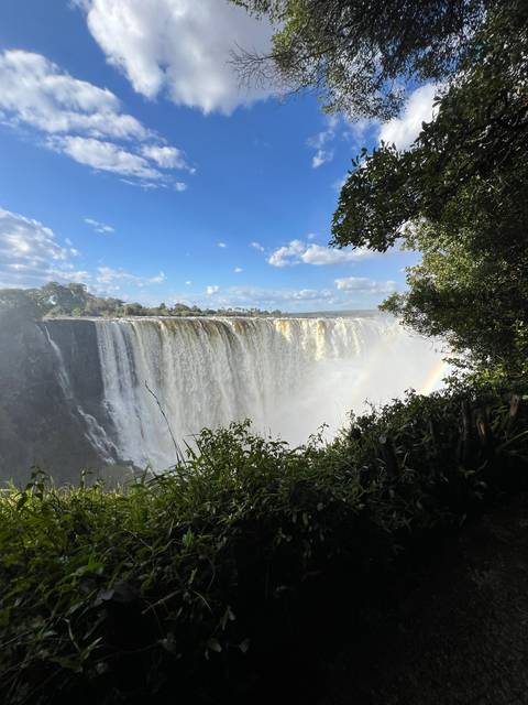 A majestic view of a large waterfall with a rainbow.