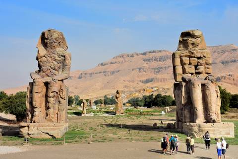 The Colossi of Memnon statues with tourists nearby.
