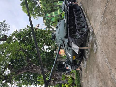      Tank displayed outdoors surrounded by trees.
  