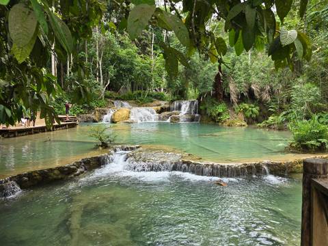       Cascading waterfalls with turquoise pools surrounded by lush jungle.
  