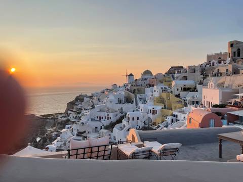 Sunset view of Santorini with white buildings and the sea.