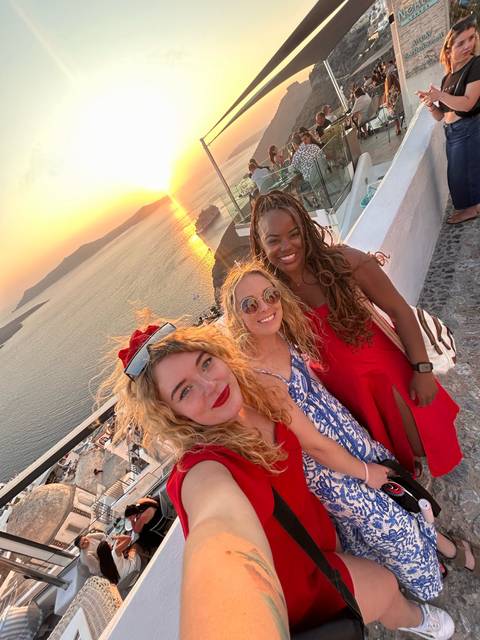 Group of friends enjoying sunset by the sea