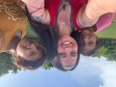 Selfie of three smiling individuals outdoors.