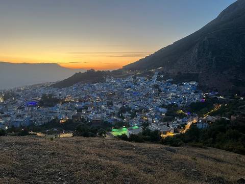 Panoramic view of a city with illuminated buildings at dusk.