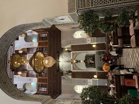 Intricate interior of a Moroccan restaurant with diners.