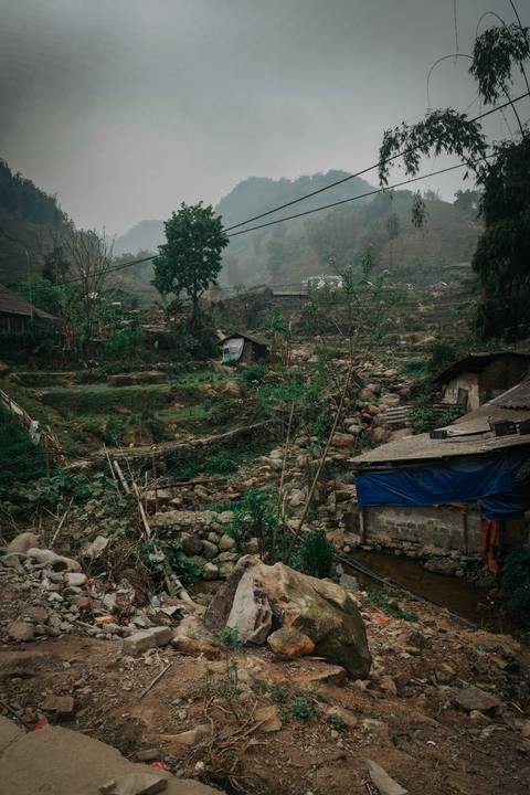       Rural landscape with traditional houses and green vegetation.
  