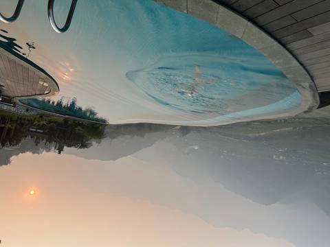       Infinity pool overlooking a misty valley at sunset.
  