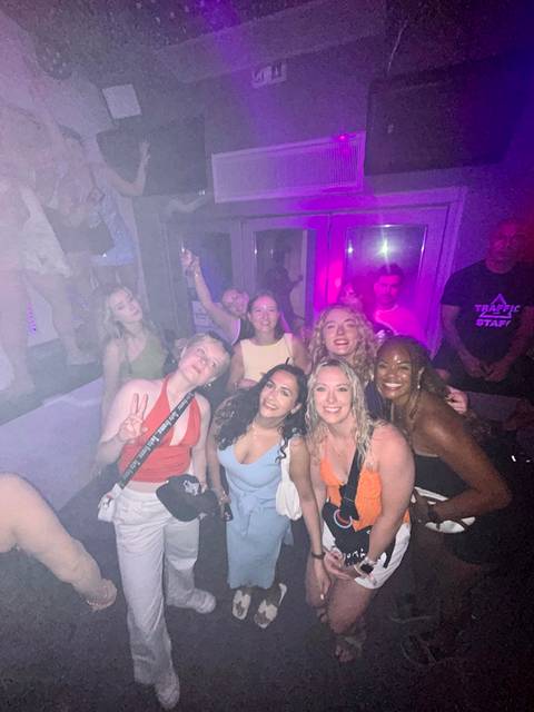 Group of friends enjoying nightlife with vibrant lights indoors.