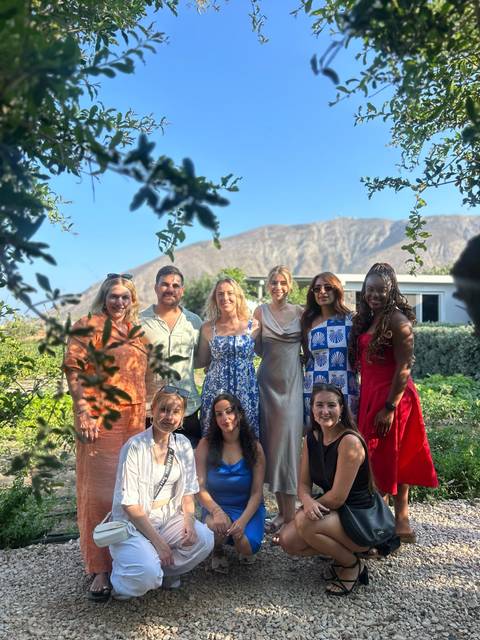 Group of people posing with a mountain in the background.