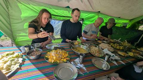 A group of people enjoying a meal inside a tent.