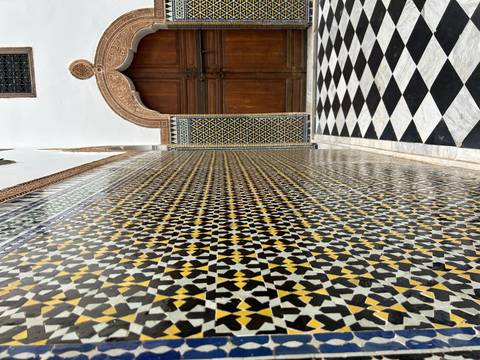       Decorative tile wall with an ornate wooden door.
  