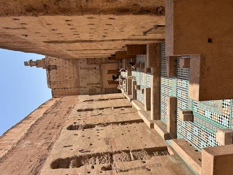       Ancient ruins with patterned floor tiles and walls.
  