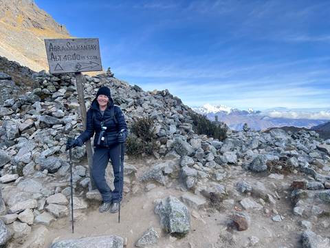 Hiker posing with a trekking sign atop Salkantay.