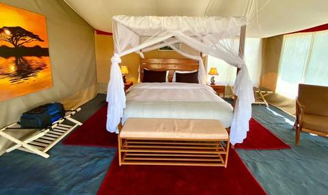 Luxurious safari tent with bed and decor.