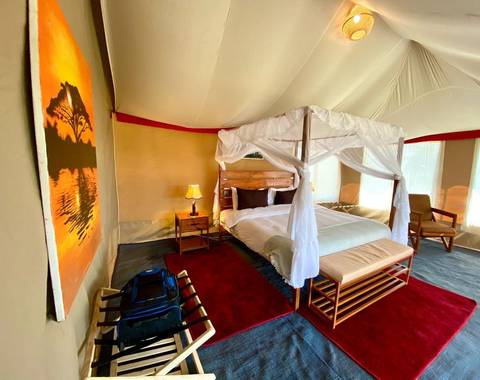 Interior of elegant safari tent with art and amenities.