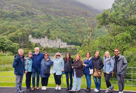 Group posing in front of a castle in an Irish countryside.