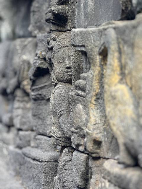       Close-up of ancient stone carvings on a wall.
  