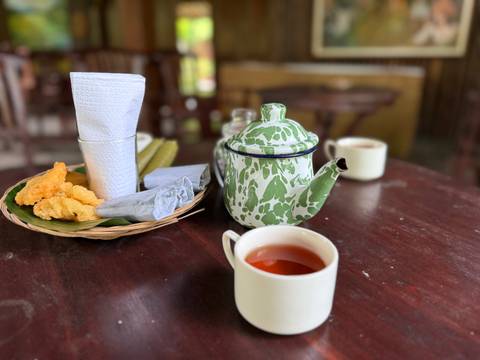       A table set with a green patterned teapot and cups.
  