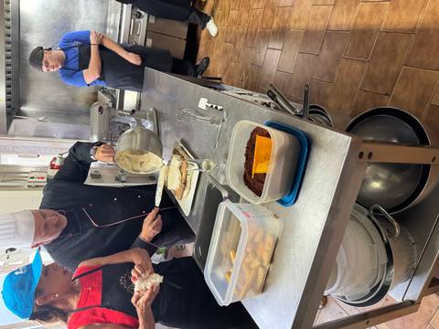       Chefs in a kitchen preparing dessert.
  