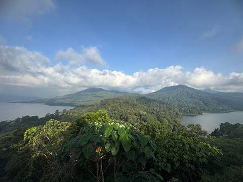       Expansive view of lakes and mountains under a blue sky.
  