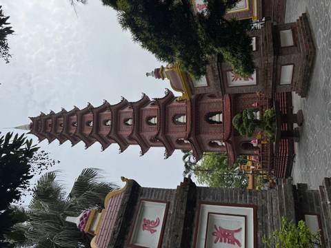       Tall pagoda with multiple tiers beside ornamental buildings.
  